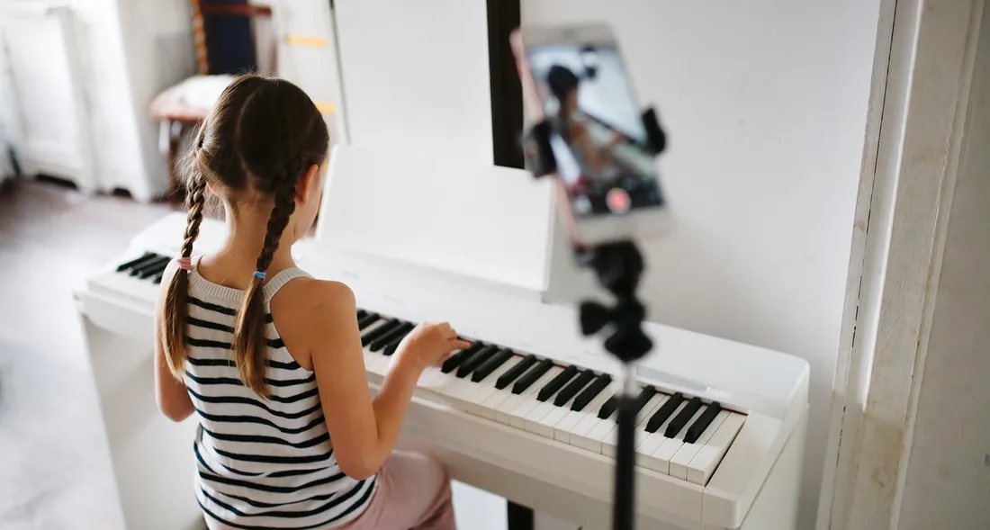 A young student practising at the piano at home