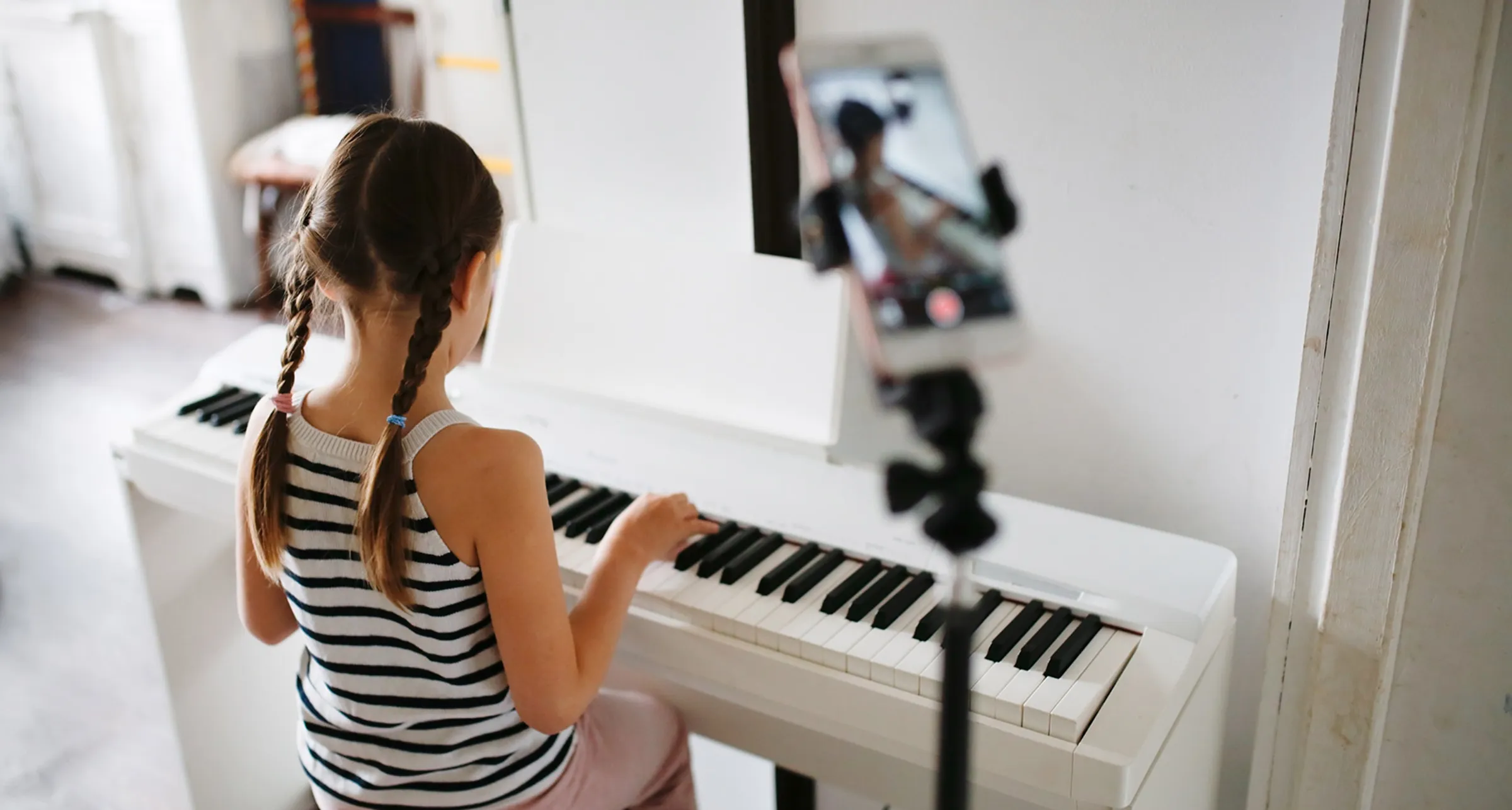 A young student practising at the piano at home